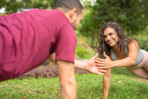 Friends training planks as a team in the park