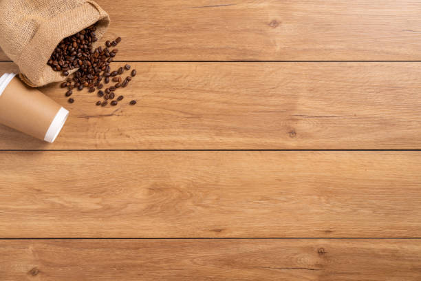 istock A coffee cup takeaway and many coffee beans are placed around on a wooden table 1777404548