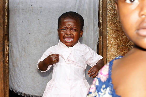llorar africana niño con su hermana pequeña en primer plano - de bajo peso fotos fotografías e imágenes de stock