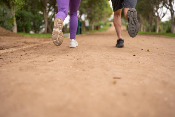 Couple jogging with sneakers, in the park.