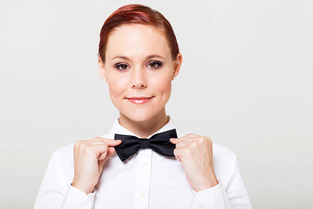 beautiful young waitress holding bow tie and smiling