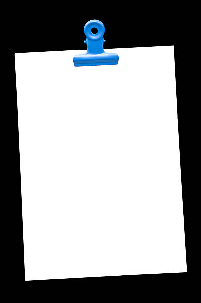 Memo pad and paper clip on black, high angle view