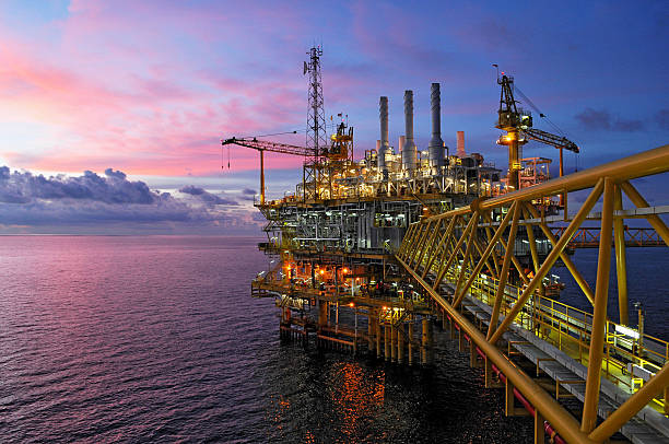 plataformas de equipo en crepúsculo - plataforma petrolífera fotografías e imágenes de stock