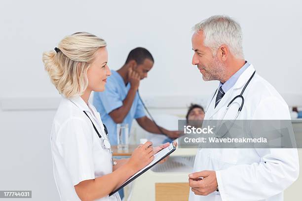 Doctors Talking Together Stock Photo - Download Image Now - 20-29 Years, 50-59 Years, Adult