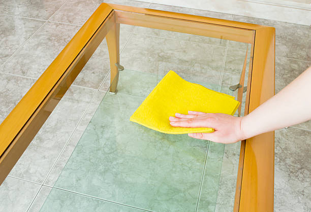 istock cleaning a glass table with yellow cloth 177745356
