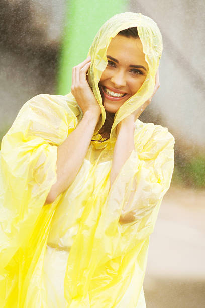 pretty woman dress in raincoat having fun in the rain
