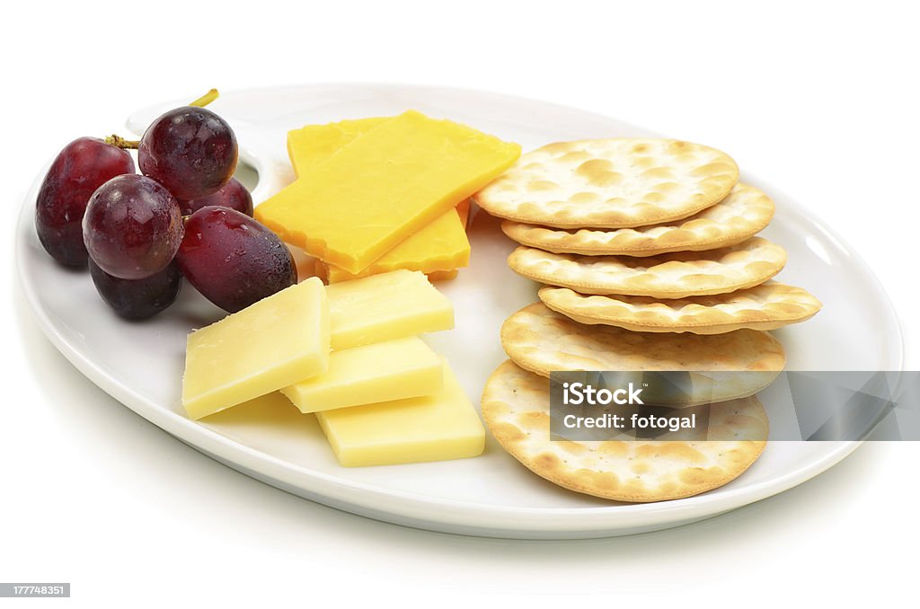 Cheese and crackers Cheese and crackers with grapes on oval white plate Cracker - Snack Stock Photo