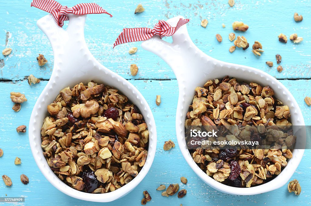 Homemade granola on wooden turquoise background Homemade granola with oatmeal, dried cranberry, almond, walnut on bright turquoise background Almond Stock Photo