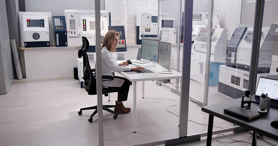 Group of Security data center operators working in a CCTV monitoring room looking on multiple monitors.Officers Monitoring Multiple Screens for Suspicious Activities.