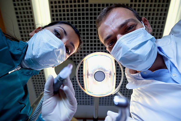 istock Dentist and assistant filling tooth to sick patient 177749878