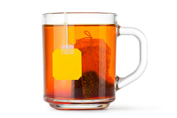 Glass teacup with teabag Glass teacup with teabag. Isolated on a white. tea crop stock pictures, royalty-free photos & images