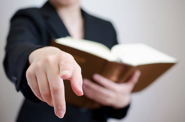 finger pointing by female with book stock photo