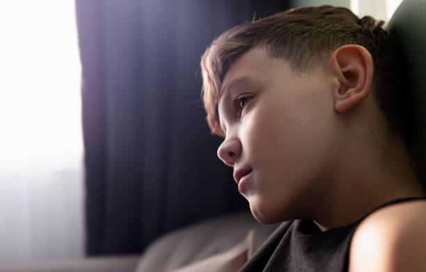 istock a boy thinking about something in a darkened room 1777509297