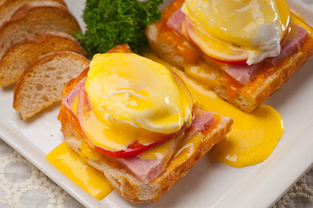 eggs benedict on bread with tomato and ham fresh eggs benedict on bread with tomato and ham hollandaise sauce stock pictures, royalty-free photos & images