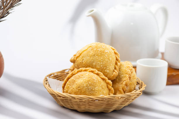 istock Curry puff, white teapot set isolated on white background. Samosa chicken fried curry bakery, meat, vegetable on wooden table. Yummy pie, Asian street food, Crispy snack eating with tea, coffee bread 1777522298