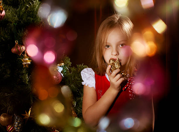 Little girl near Christmas tree with magic irradiance stock photo