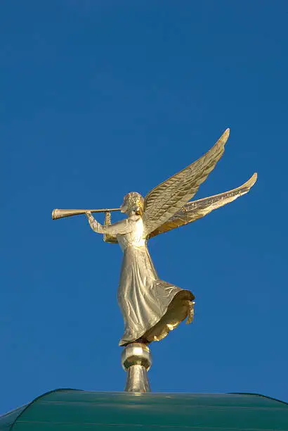 Golden angel weathervane with a pipe on the tower of the monastery in Diveevo