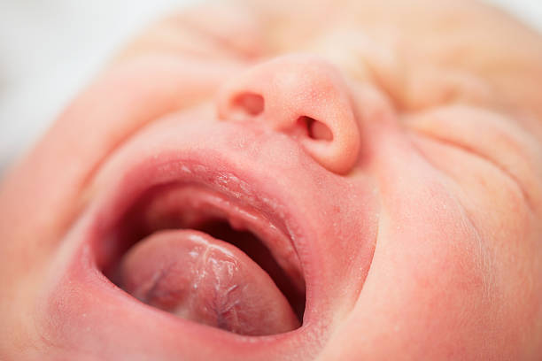 Newborn Newborn baby is crying - selective focus human tongue stock pictures, royalty-free photos & images