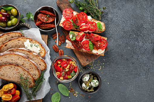 Italian antipasti snacks set. Tasty bruschettas with cheese, sun-dried tomatoes. Traditional food concept. Top view., copy space.