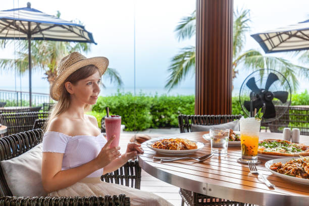 istock Tranquil seaside meal, young lady in straw hat 1777551598