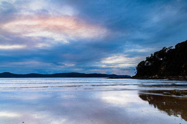 Wet weather sunrise with rain clouds at Umina Point in Umina Beach on the Central Coast, NSW, Australia.