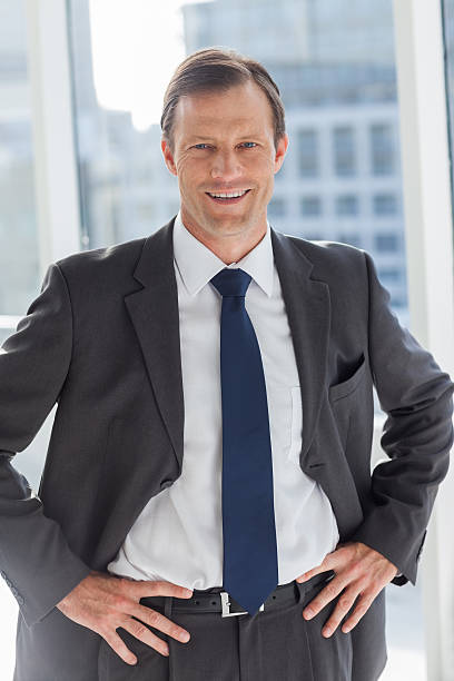 istock Smiling businessman with his hands on hips 177755466