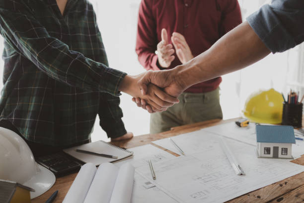 istock The architect shake hands with the foreman as the job was agreed upon, An engineer contracts with a company to construct a building, Engineer and architect check hand as work is finalized. 1777559438