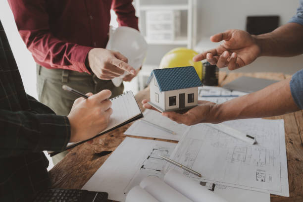istock Architects and engineers work together to come up with solutions to house building problems, The property is about to be designed by a group of engineers, Architects are reviewing plans together. 1777561111