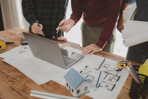 istock Architects and engineers work together to come up with solutions to house building problems, The property is about to be designed by a group of engineers, Architects are reviewing plans together. 1777562188