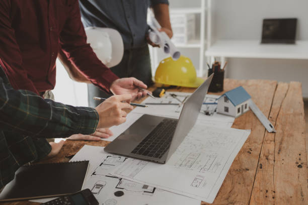 istock Architects and engineers work together to come up with solutions to house building problems, The property is about to be designed by a group of engineers, Architects are reviewing plans together. 1777562203