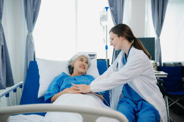 istock Doctor in white suit take notes while discussing and Asian elderly, woman patient who lying on bed with receiving saline solution in hospital or clinic. 1777573129