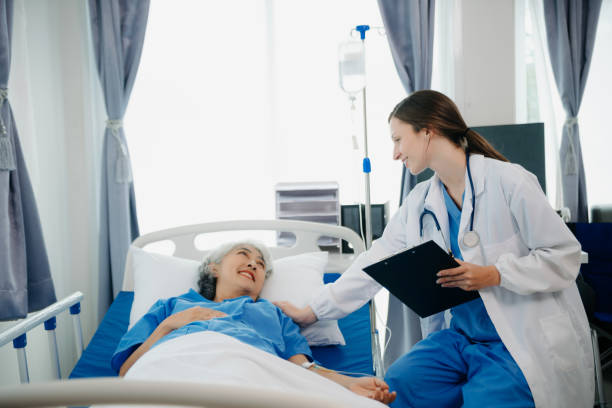 istock Doctor in white suit take notes while discussing and Asian elderly, woman patient who lying on bed with receiving saline solution in hospital or clinic. 1777573135