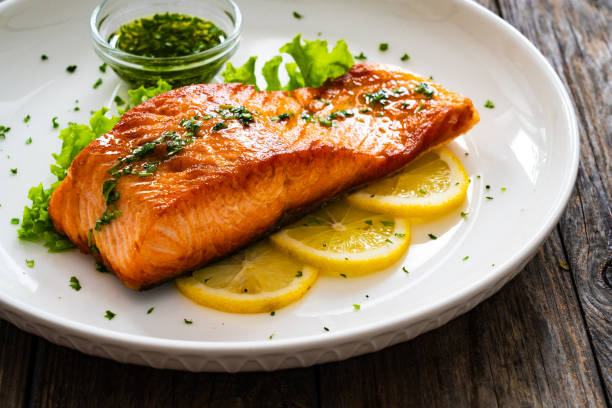 istock Seared salmon with fresh vegetables on wooden table 1777592484