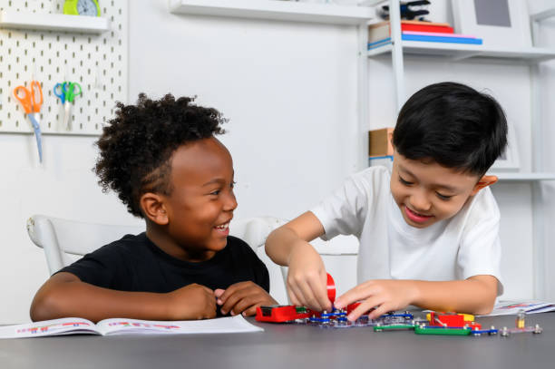 istock Two Children of different ethnicities are playing together and enjoy learning about electrical circuits basics on table in a homeschool classroom. Brainstorming ideas and sharing their knowledge. 1777597542