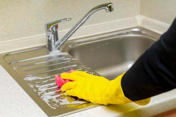 istock hand in a yellow glove washes a kitchen sink with a sponge. 1777602456