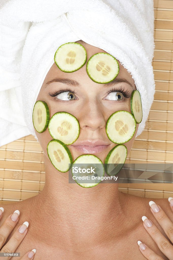 Woman with facial mask of cucumber Young beautiful woman with facial mask of cucumber on her face lying at spa salon One Woman Only Stock Photo