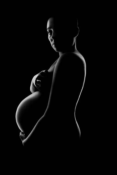jovem mulher grávida abraça o bump - teenage pregnancy mother social issues family - fotografias e filmes do acervo