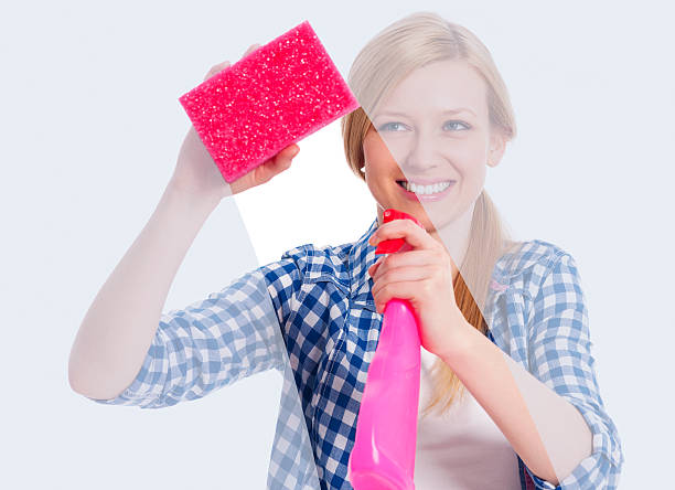 istock Young woman standing behind window and washing it 177762978