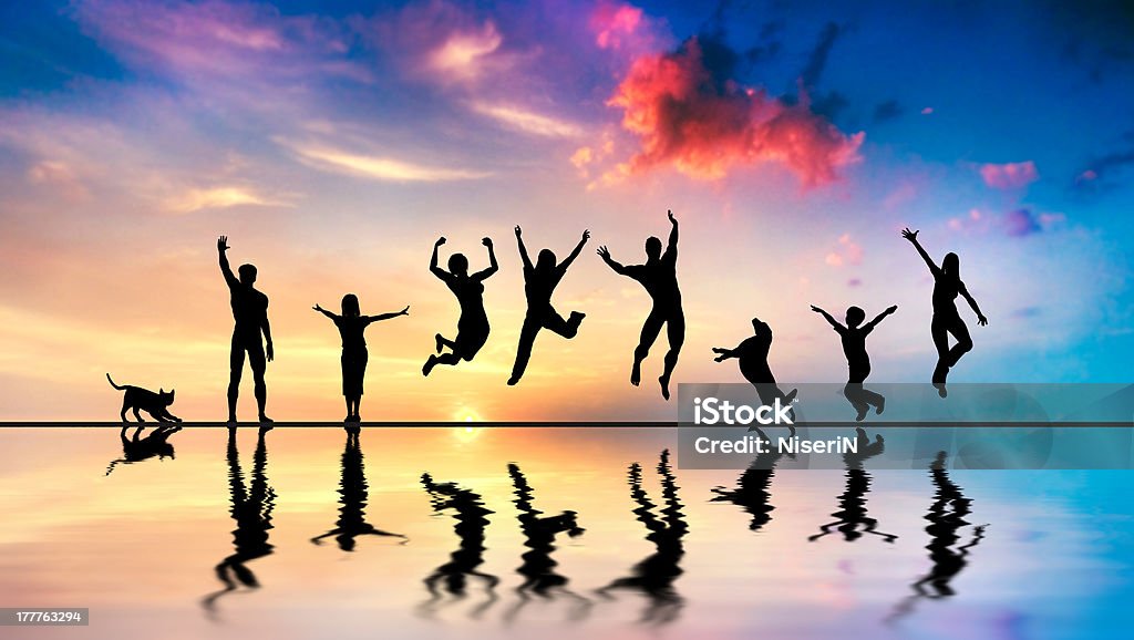 Happy friends, family with dog and cat jumping at sunset Happy group of friends, family with dog and cat jumping together at sunset, water reflection Dog Stock Photo