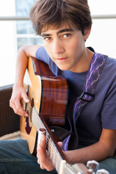 Brooding Monada adolescente tocando guitarra acústica - foto de stock