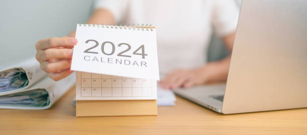 istock 2024 Year Calendar on table with business woman using laptop computer. countdown, Happy New Year, Resolution, Goals, Plan,  Action, Mission and financial Concept 1777646071