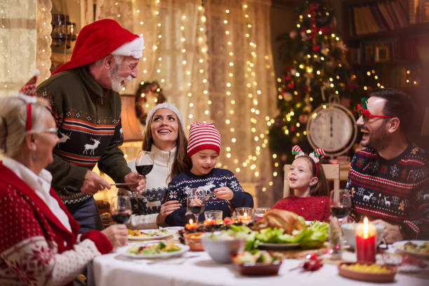istock Happy multi-generation family enjoying in Christmas dinner at dining table. 1777673941