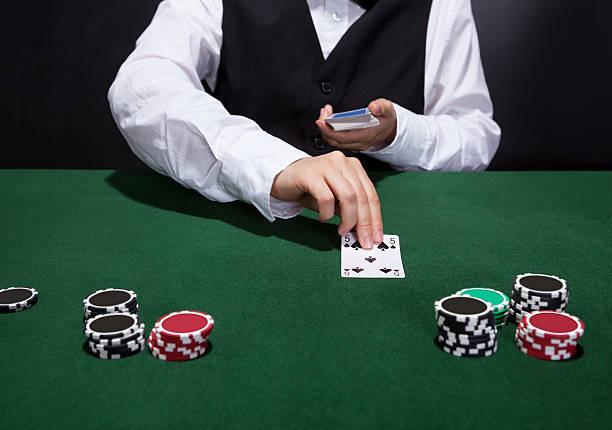 Croupier dealing cards Croupier dealing cards in a poker game placing them face up on the green baize of the gaming table black jack live dealers stock pictures, royalty-free photos & images