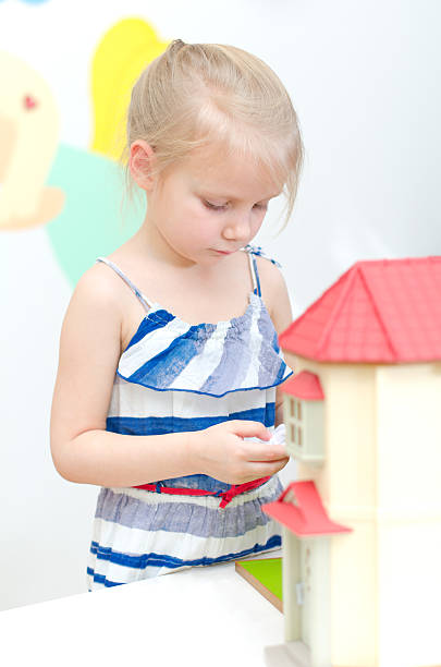 istock Little girl playing with dollhouse 177769021