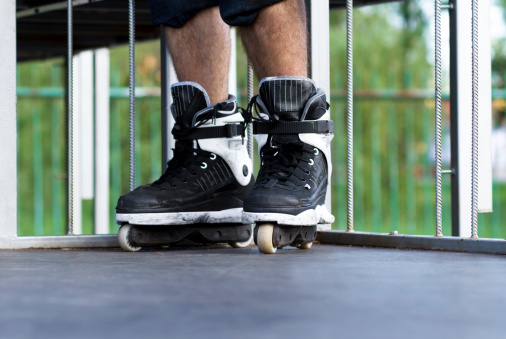 Skater wearing pair of 2011 aggressive rollerblades for professional tricks. New trendy model for tough kids!