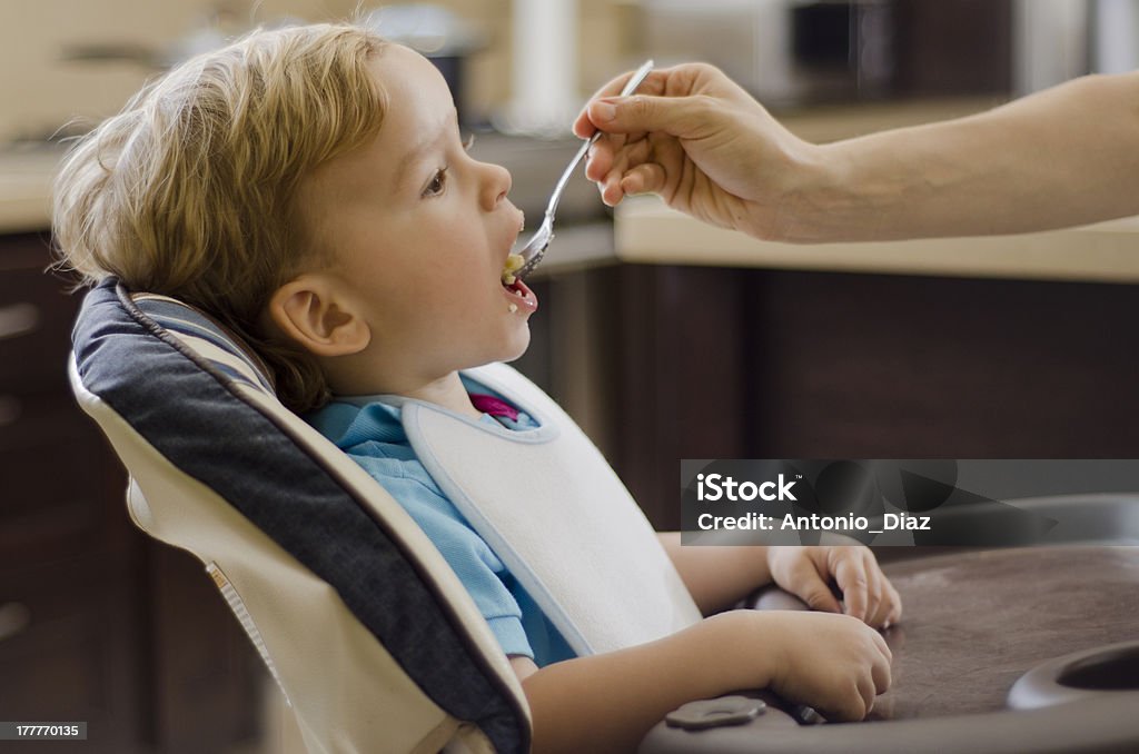 Loira menino ser alimentada por sua mãe - Foto de stock de Alimentar royalty-free