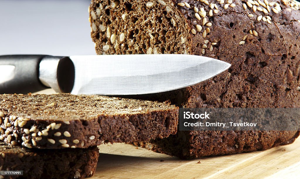 bread closeup photo of bread and knife lying on chopping wooden board Baked Stock Photo