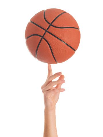 Close-up Of Hand Spinning Basket Ball On White Background