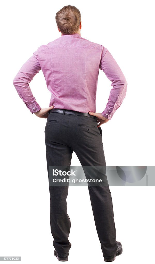 back view of Business man  looks ahead back view of Business man  looks ahead. Young guy in pink shirt watching.  Rear view people collection.  backside view of person.  Isolated over white background. broad-office worker put his hands on his hips thoughtfully reflects Adult Stock Photo