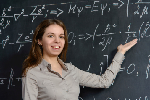 Student girl standing near blackboard in the classroom